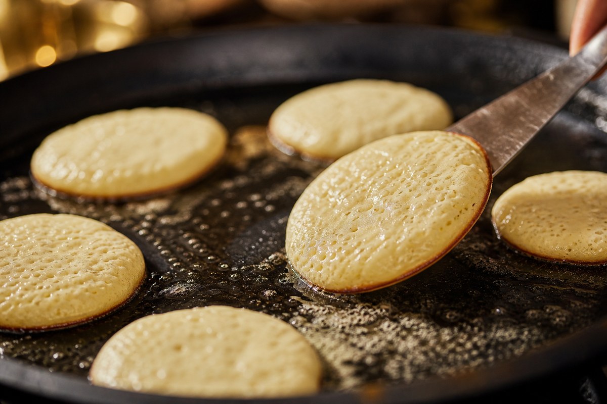 Blinis qui gonflent dans une poêle beurrée