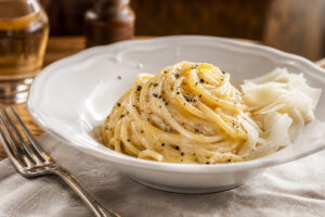 Assiette de spaghetti cacio e pepe brillants avec poivre noir et pecorino