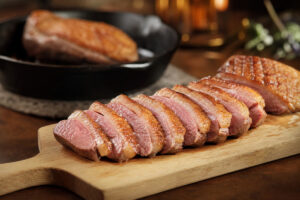Magret de canard tranché rosé avec peau dorée et gras fondu