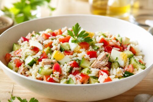 Salade de riz froide avec légumes, œufs, thon et herbes fraîches