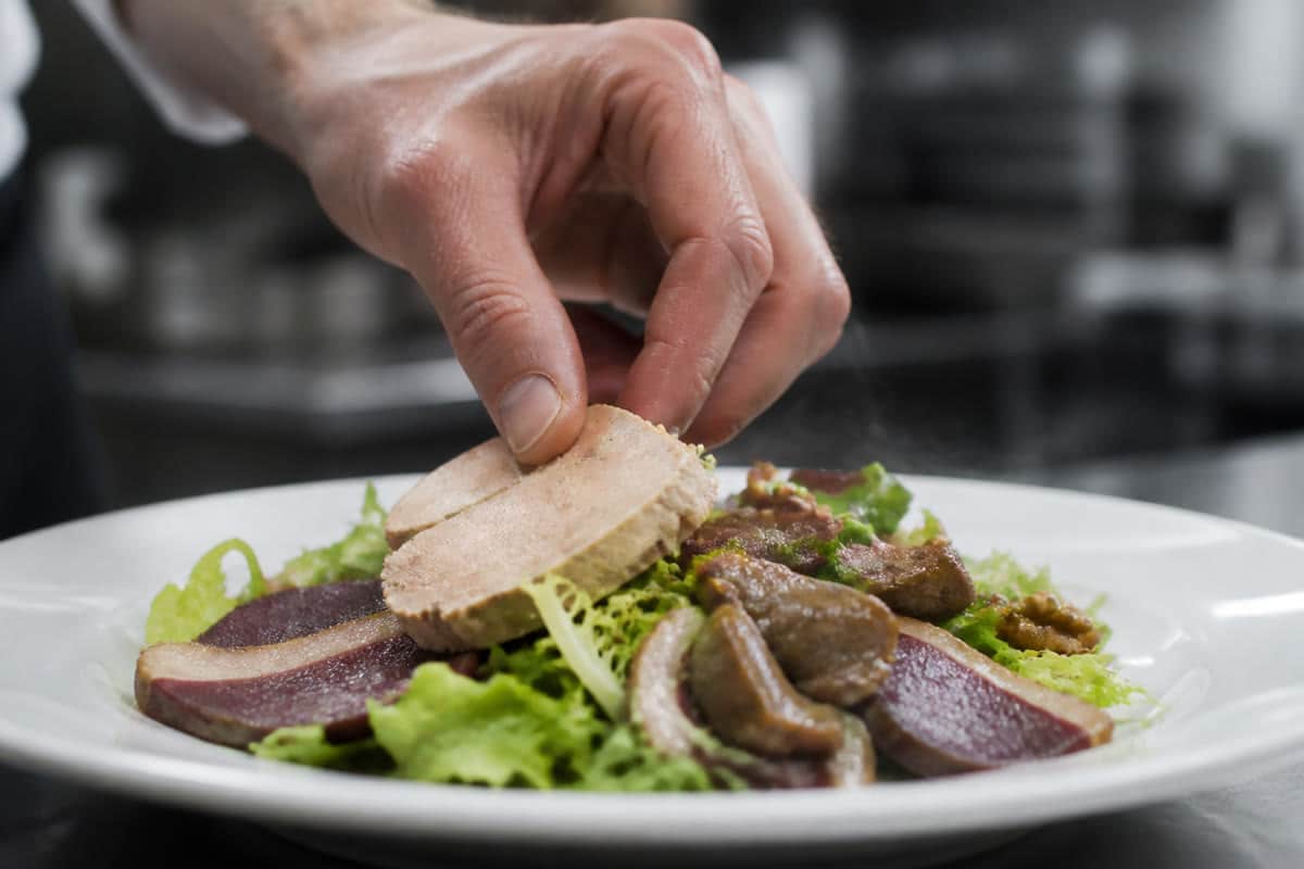 Foie gras posé au dernier moment sur une salade landaise