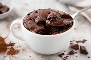 Mug cake chocolat dans une tasse avec cœur fondant à la cuillère