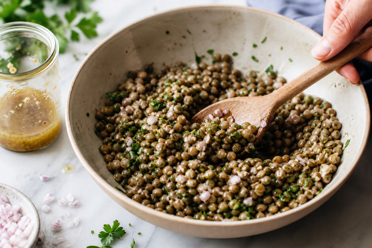 Lentilles vertes tièdes mélangées à une vinaigrette avec échalote et persil